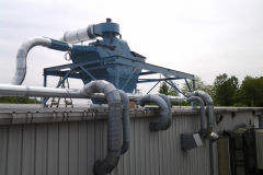 2 large slant screen separators mounted back to back on the roof of the building with the chute penetrating the roof and emptying into the baler located inside of the building.