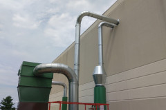 Main pneumatic conveying lines penetrating the outside wall and running into the material handling fans and out of the fans into the slant screen separator.  There is a large exhaust conveying line which runs to the balance fan where the conveying air is exhausted to atmosphere.